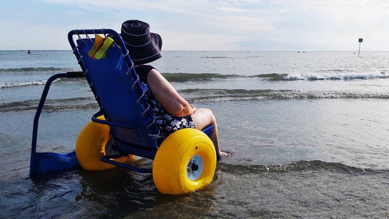 Mujer con una silla anfibia en el mar