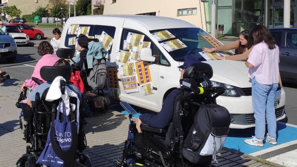Personas con discapacidad envuelven un coche con billetes de 200 euros para visibilizar el respeto a las plazas PMR