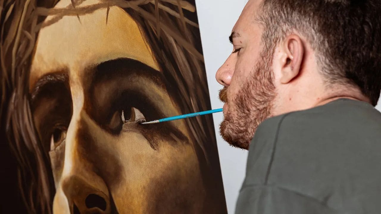 Lorenzo Higueras, joven con discapacidad, pintando con la boca