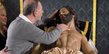 Personas ciegas palpan al Cristo Yacente de la Hermandad de la Vera-Cruz en Utrera