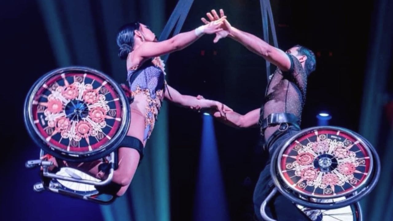 Dúo de acróbatas en silla de ruedas realizando una figura aérea