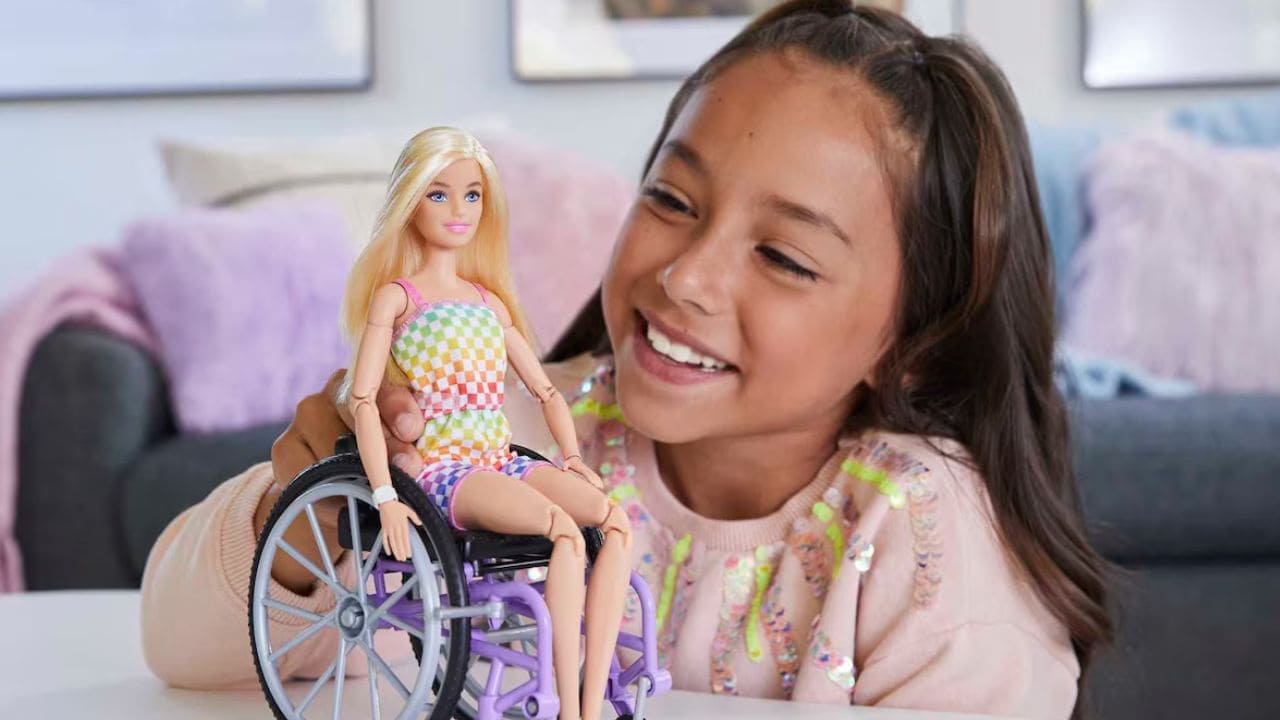 Niña con barbie en silla de ruedas
