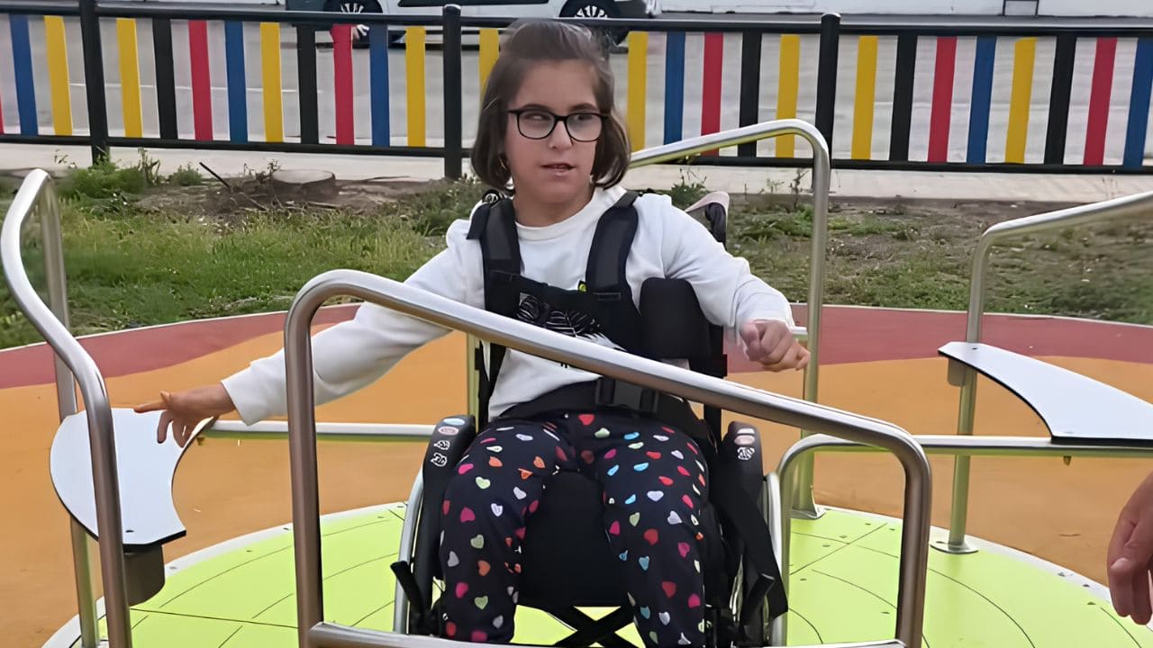 Mireia, niña con parálisis cerebral, en un parque infantil accesible