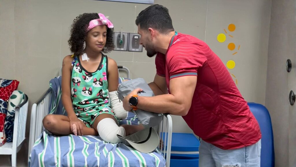 Juan Pablo Dos Santos con una niña amputada por los terremotos de Venezuela